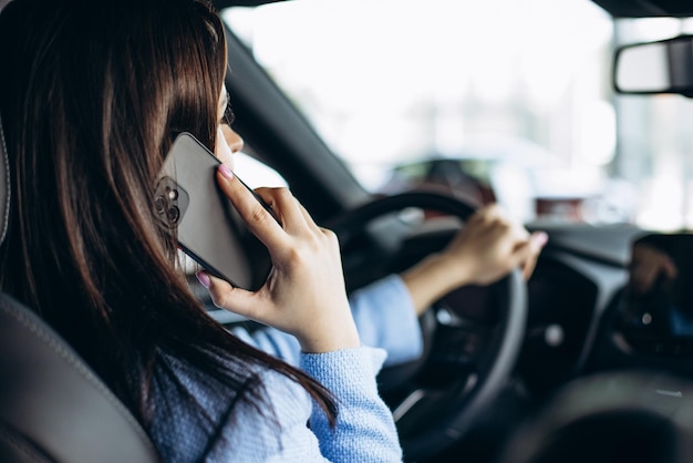 Woman using phone while driving in car