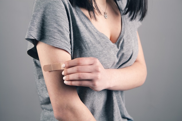 Woman using scotch tape on her injured arm