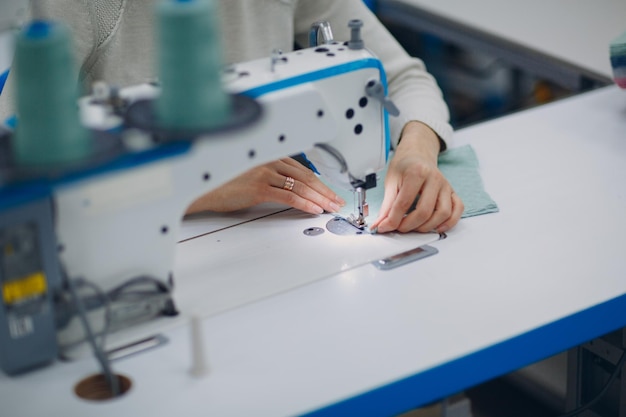 Foto donna che usa la macchina da cucire sul tessuto al laboratorio