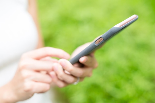 Woman using smart phone at green park