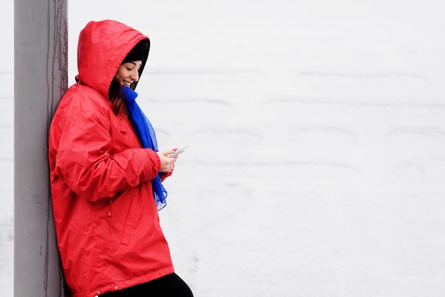 Foto donna che usa lo smartphone mentre sta all'aperto durante l'inverno