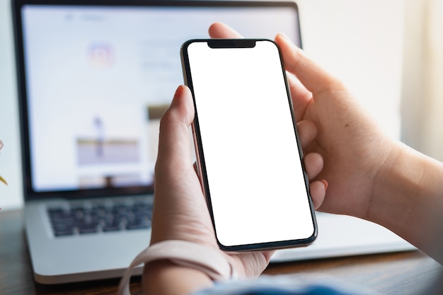 Woman using Smartphone. Blank screen mobile phone for graphic display montage.