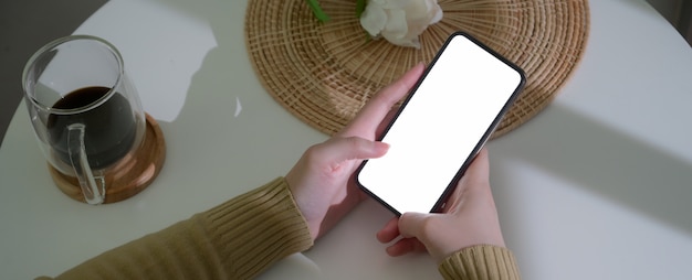 Woman using smartphone on coffee table