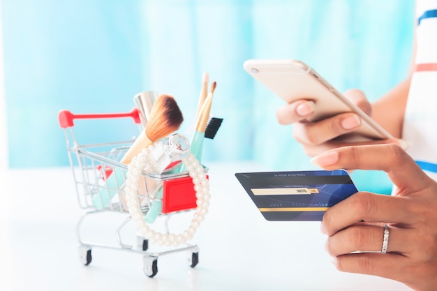 Photo woman using smartphone and credit card shopping beauty items. online shopping, e-payment