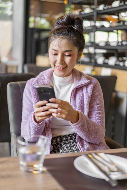 여자 레스토랑에서 스마트 폰을 사용 하여