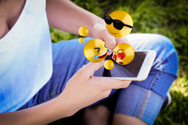 Photo woman using smartphone sending emojis.