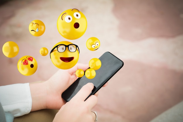 Woman using smartphone sending emojis.