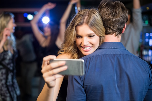 Женщина используя smartphone пока обнимающ парня