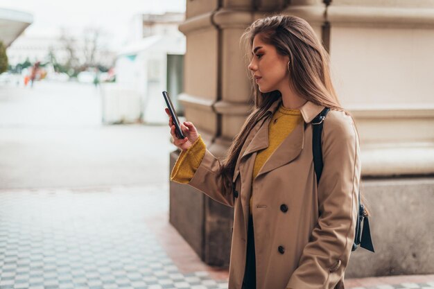 外を歩きながらスマートフォンを操作する女性