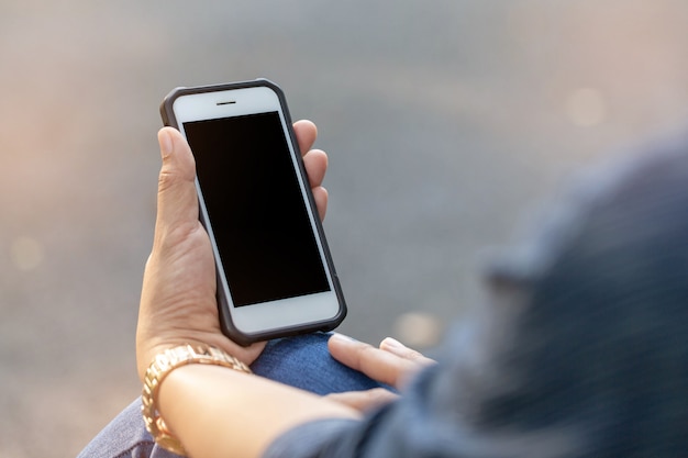 Woman using smartphone with dark screen