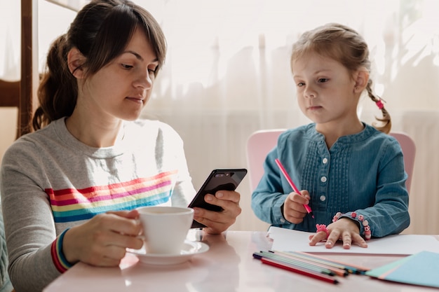 Woman using a smartphone with her daughter