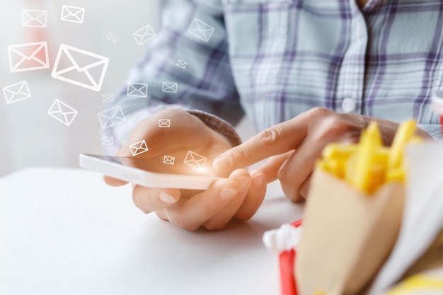 A woman using a smartphone with the word mail on the screen.