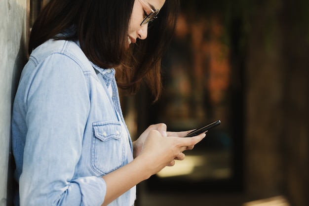 写真 女性の幸せと自由時間で働くスマートフォンを使用して。