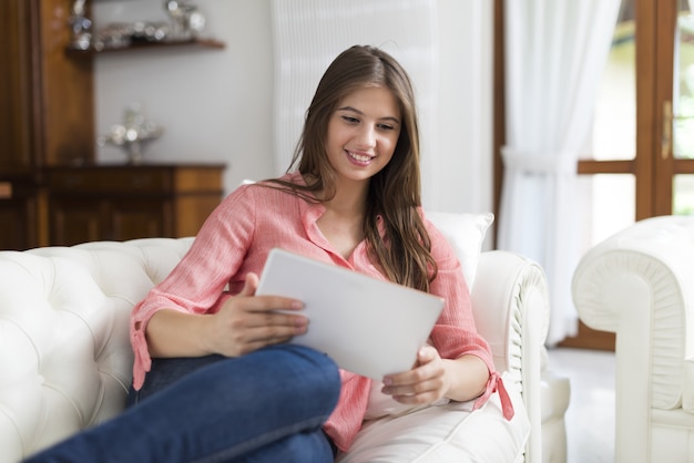 Woman using a tablet in her house living room