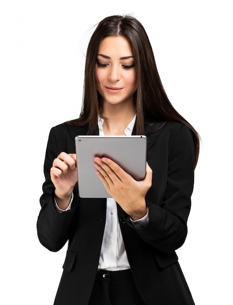 Woman using a tablet isolated on white wall