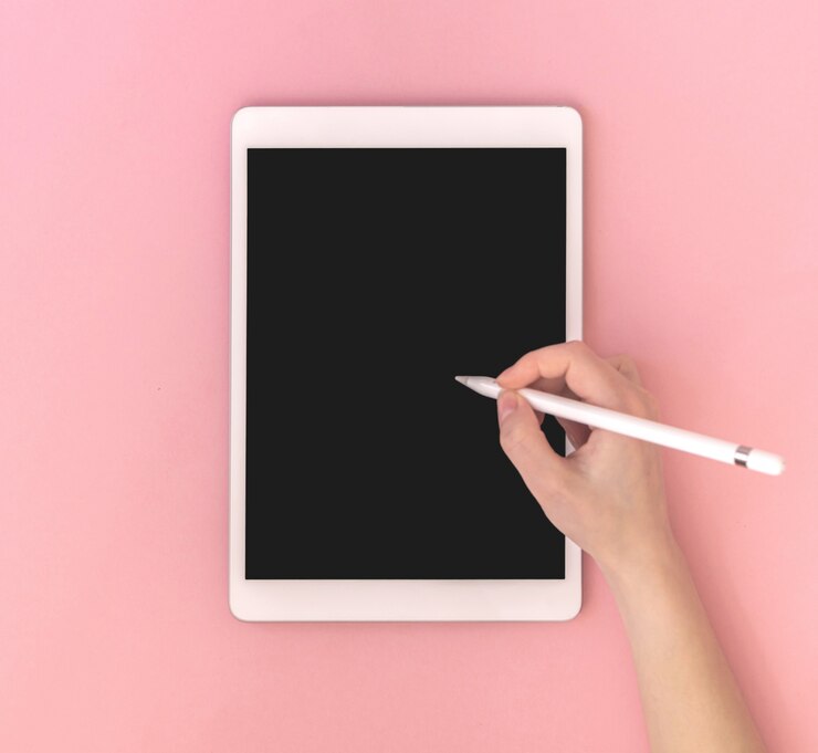 空白の画面、上面図、ピンクのカラフルな背景写真とスタイラスモックアップとタブレットを使用している女性