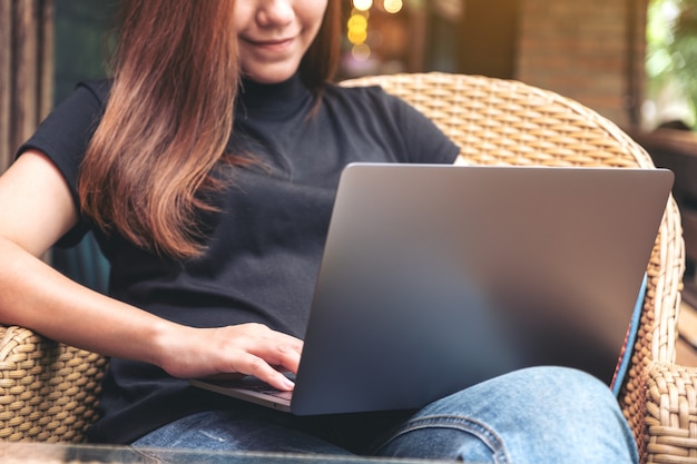 A woman using and typing on laptop keyboard