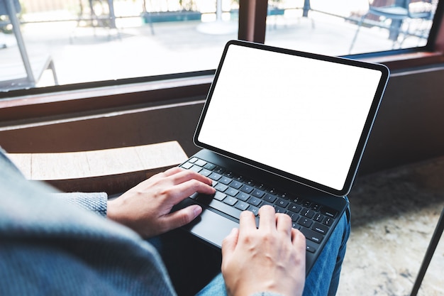  of a woman using and typing on tablet keyboard with blank white desktop screen as computer pc