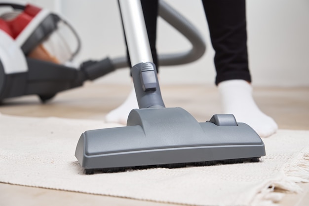 Woman using vacuum cleaner at the floor