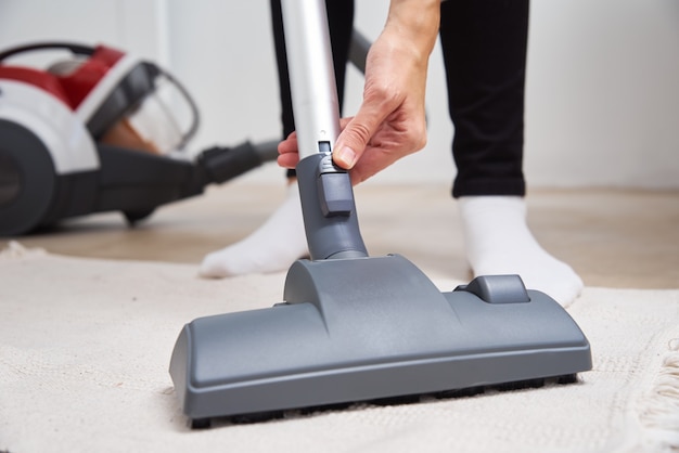 Woman using vacuum cleaner at the floor