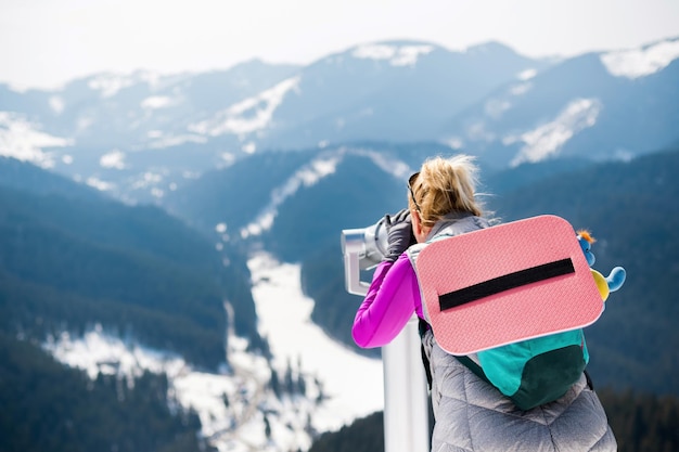 Woman using viewing binoculars in the spring Carpathians Romania