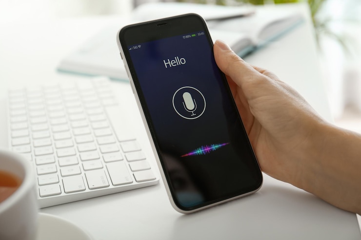 Photo woman using voice search on smartphone at white table closeup