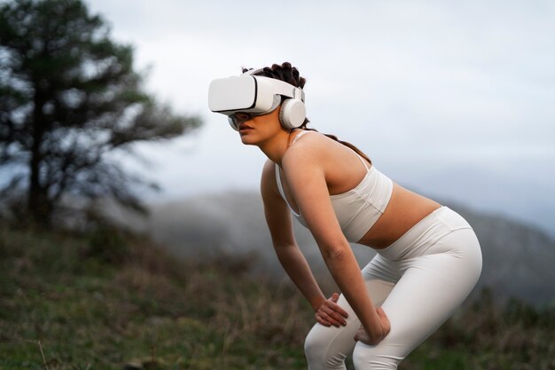 Foto donna che utilizza occhiali vr per esercitare all'aperto nella natura