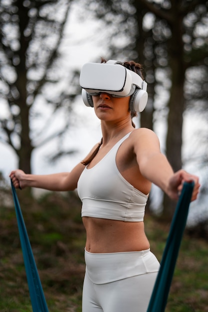 VR 안경을 사용하여 탄성 밴드로 야외에서 운동하는 여성