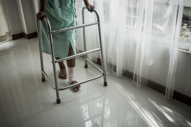Женщина, использующая ходячие средства в больничной палате