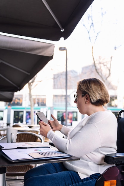 Photo woman using wheelchair working with a tablet