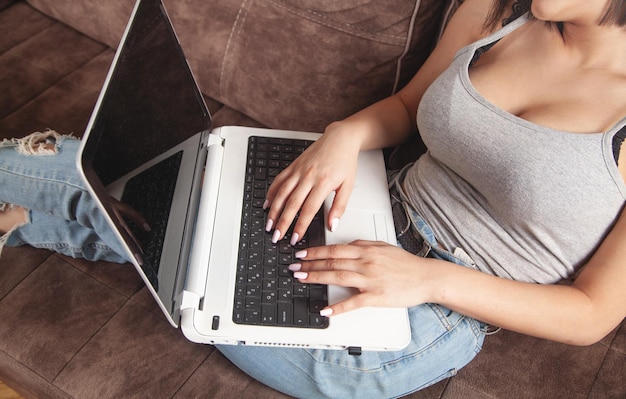 Woman using white laptop computer at home