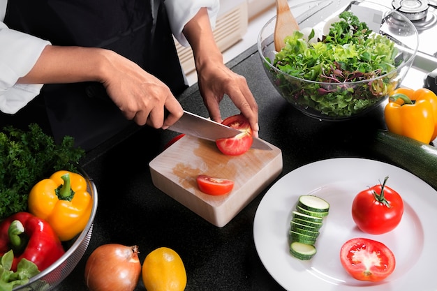 Donna vegana che cucina cibo sano e prepara insalata per cena in una cucina