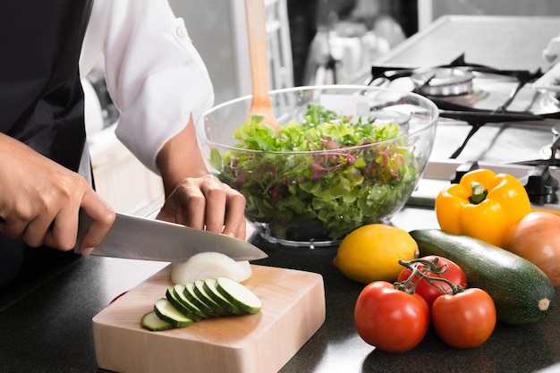 Donna vegana che cucina cibo sano e prepara insalata per cena in una cucina