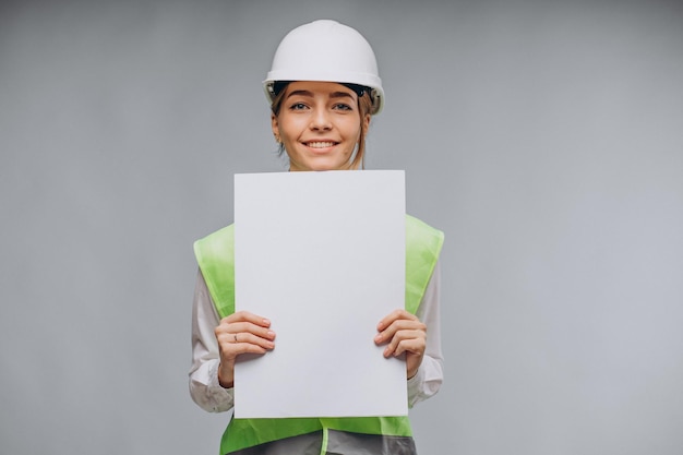 Woman in vest wearing helmet and holding papers