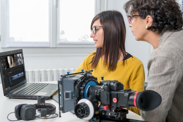 Woman video editor and young assistant