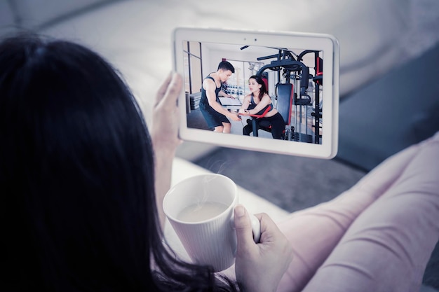 Woman viewing instructional workout video on tablet computer