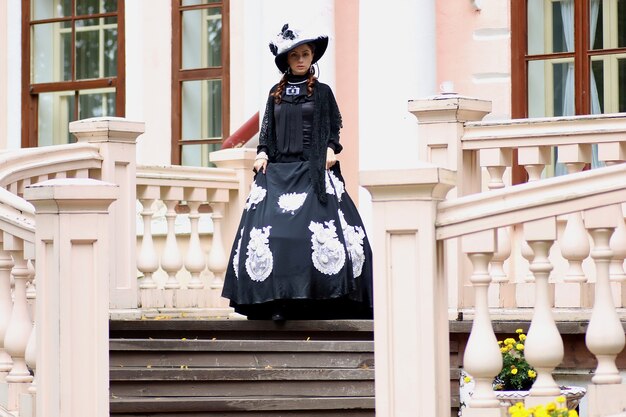 Woman in vintage dress on porch of castle