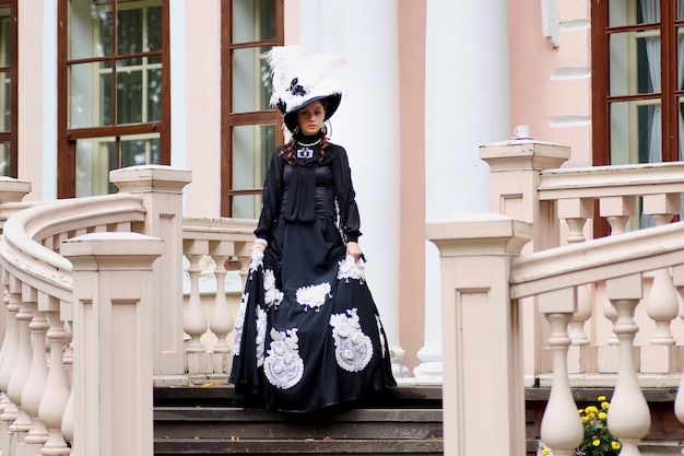 Woman in vintage dress on porch of castle