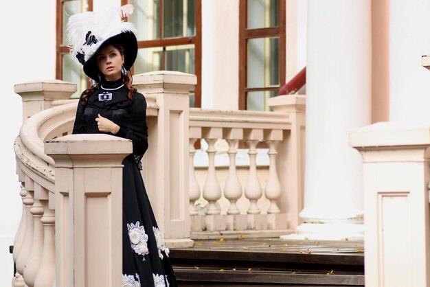 Woman in vintage dress on porch of castle