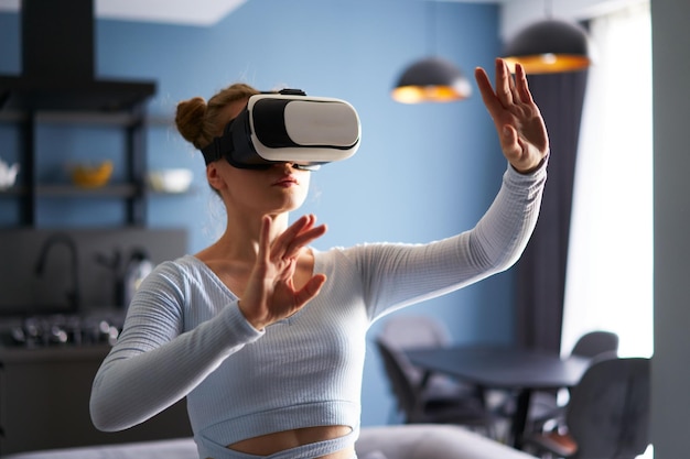 Женщина в очках виртуальной реальности входит в метавселенную и управляет иммерсивным опытом с помощью жестов рук