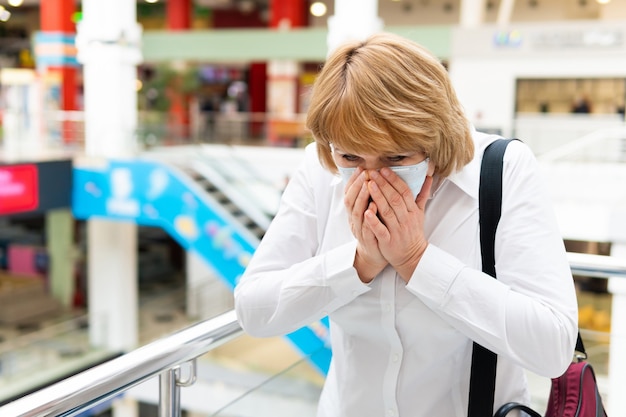 A woman in a virus mask walks around a public place in the city.