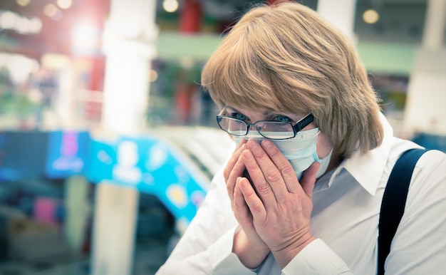 A woman in a virus mask walks around a public place in the city.