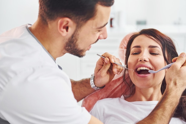 Photo woman visiting dentist in clinic conception of stomatology