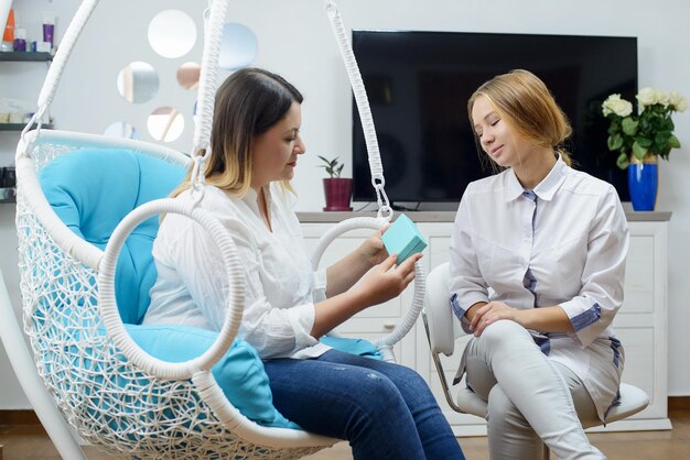 Woman visits young cosmetologist doctor The doctor consults with the patient