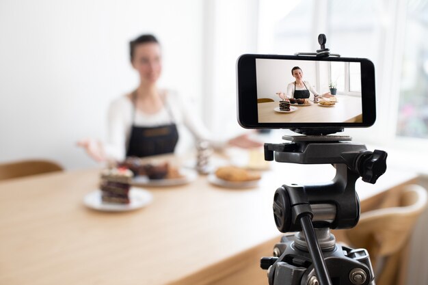 フードチャンネルの女性vlogger録画ビデオ。電話でvlogのビデオを録画する調理器具のシェフ
