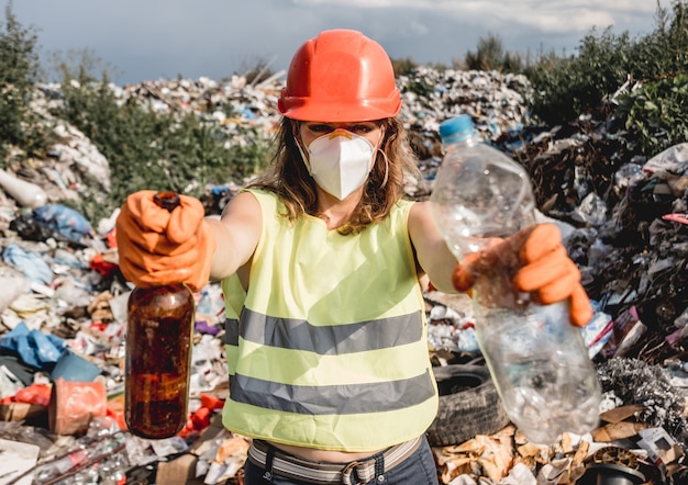 女性ボランティアは、プラスチック製のゴミのフィールドをきれいにします。