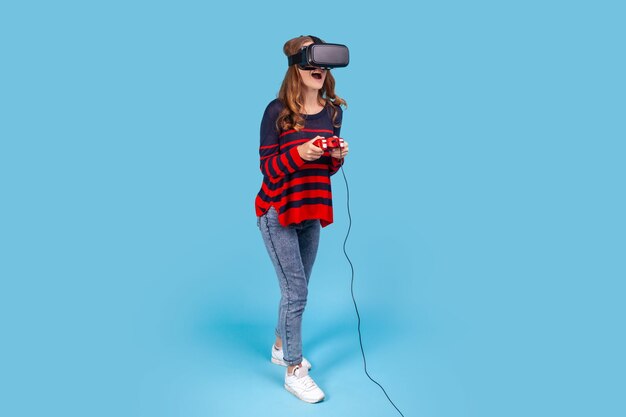 VRメガネヘッドセットの女性は、興奮した表情を体験しているゲームをプレイしている手でジョイスティックを保持します