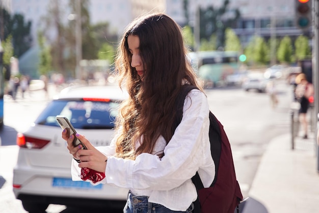 スペインでタクシーが通り過ぎる中、ライドシェアを待つ女性