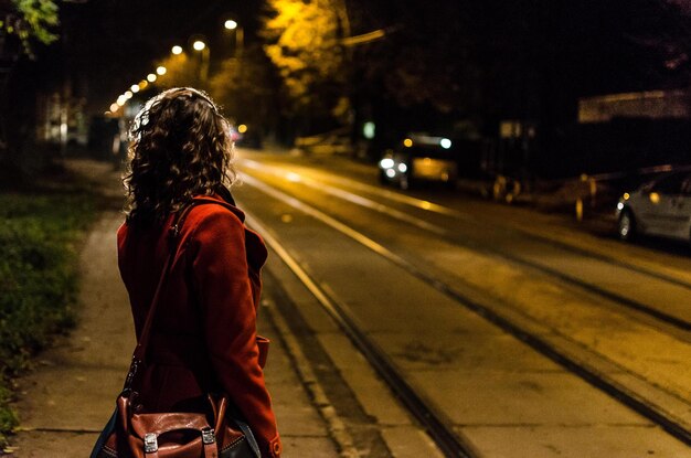 Foto donna che aspetta per strada di notte