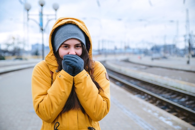 Woman waiting for train at railway station. frozen while waiting train